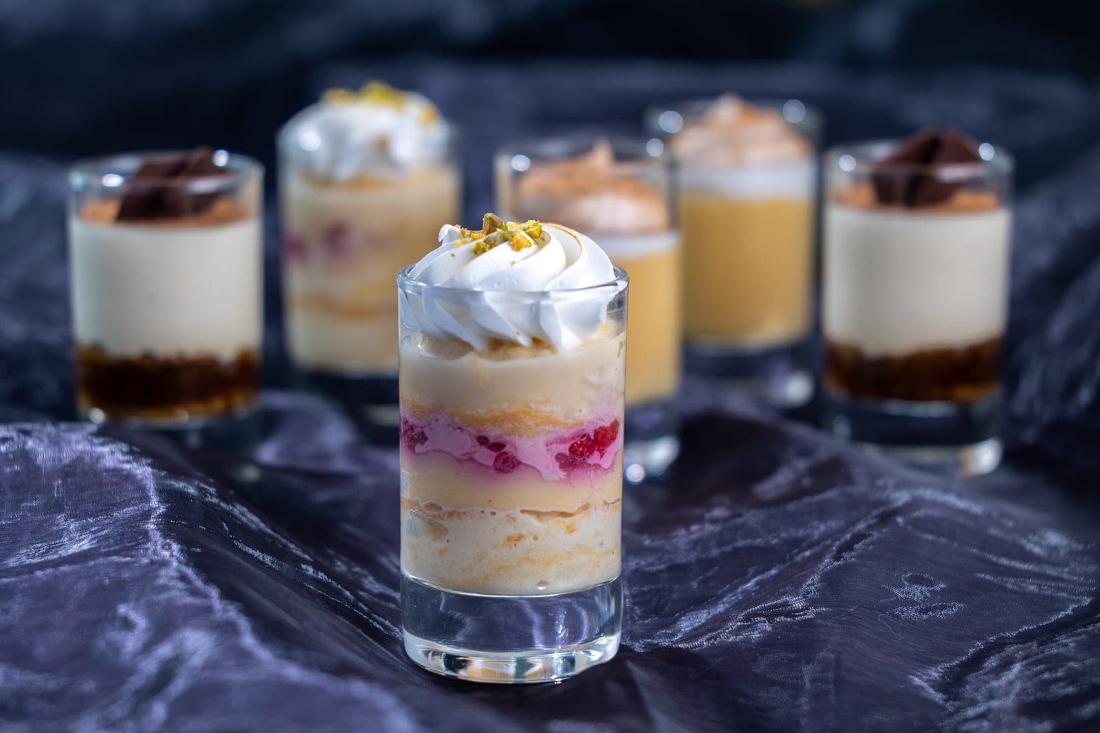 Vasitos de postre individuales presentados sobre fondo oscuro