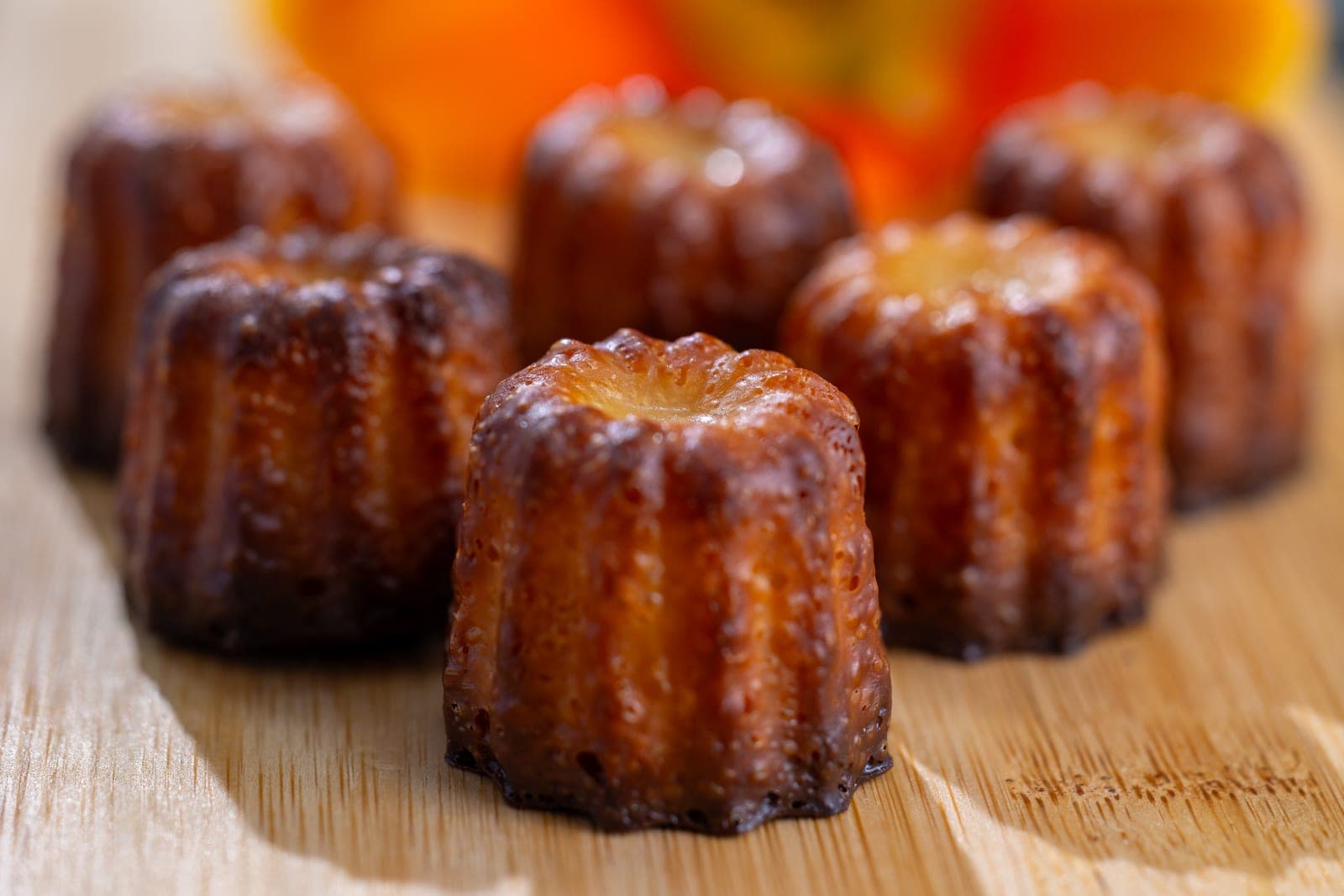 Canelés artesanales dorados sobre tabla de madera